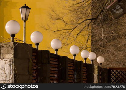 Number of round street lamps not burning on the fence in the evening. number of street lights on the fence in evening