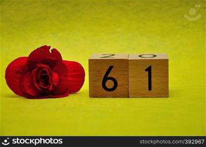 Number sixty one with a red flower on a yellow background