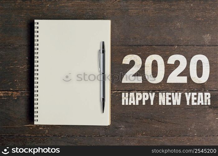 Numbers 2020 for Happy New Year and notebook with pen for copy space.