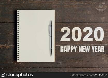 Numbers 2020 for Happy New Year and notebook with pen for copy space.