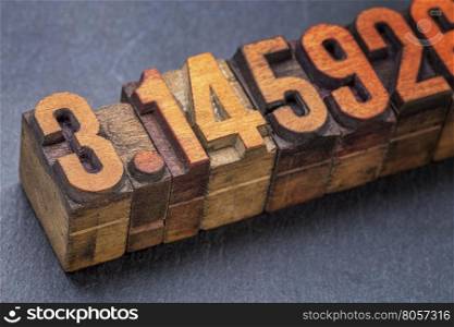 numerical representation of the pi number - vintage letterpress wood type against a slate stone