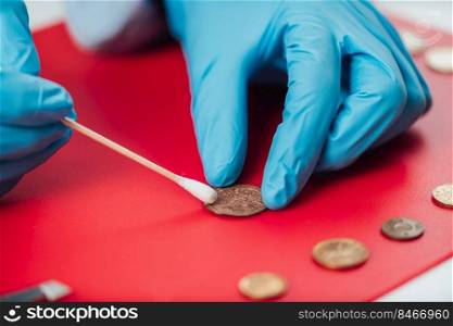 Numismatist Cleaning Ancient Coins Collection