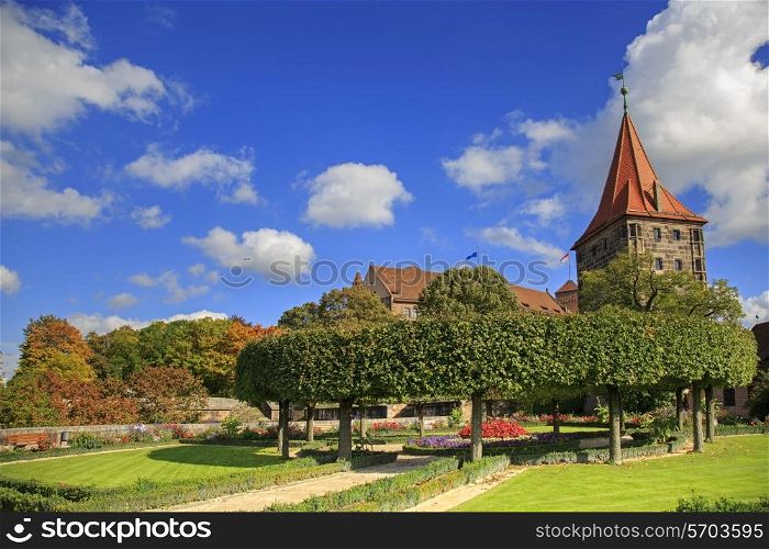 Nuremberg Castle with blue sky and trees in garden&#xA;
