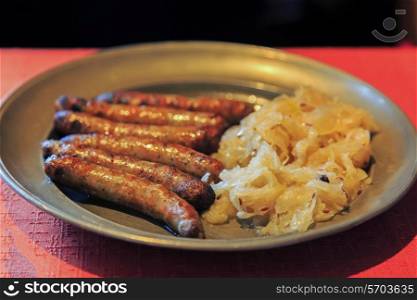 Nuremberg sausages with cabbage and spices on metal plate&#xA;