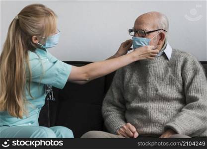 nurse adjusting old man s medical mask
