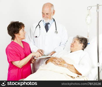 Nurse and doctor discussing a hospital patient&rsquo;s chart.