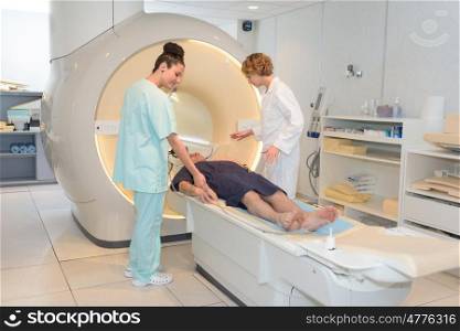 nurse and radiologist preparing patient for ct scan