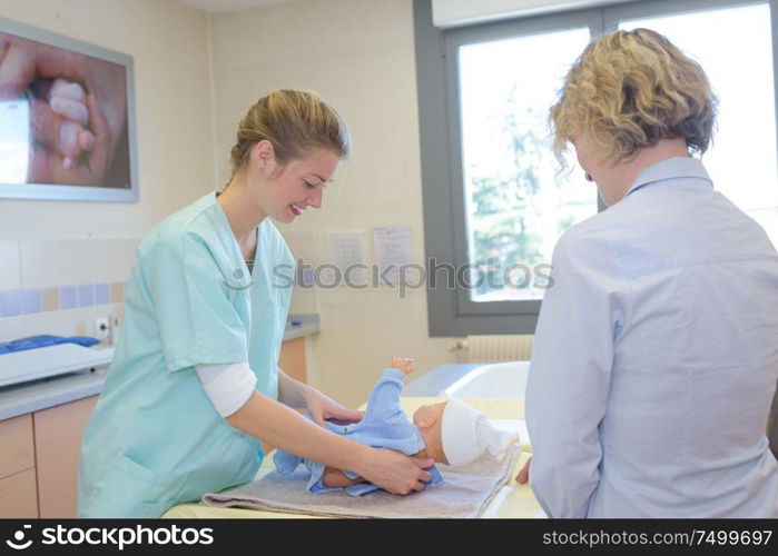 nurse changing a babys diaper at hospital