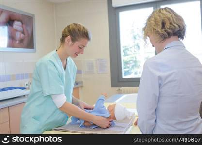 nurse changing a babys diaper at hospital