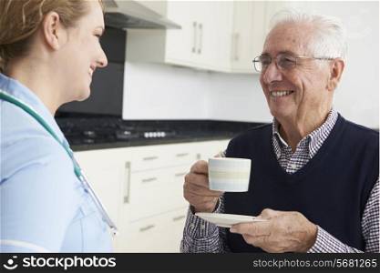 Nurse Chatting With Senior Man During Home Visit