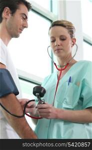 Nurse checking a patient&rsquo;s blood pressure
