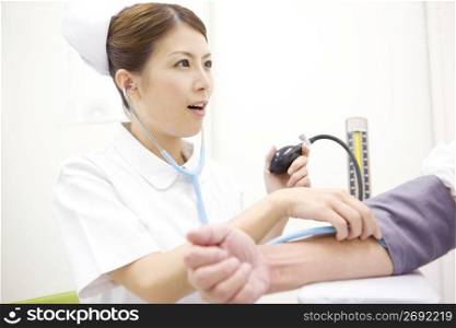 Nurse checking blood pressure