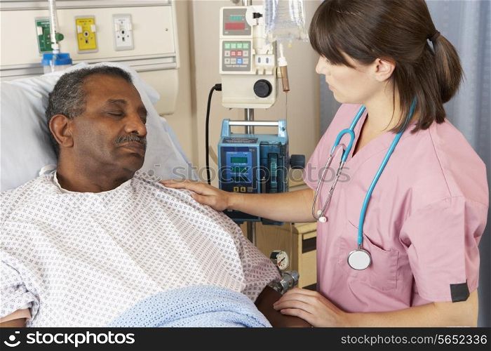 Nurse Checking Senior Male Patient On Ward