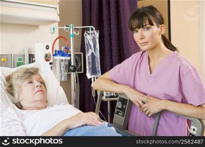 Nurse Checking Up On Patient Lying In Hospital Bed