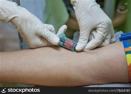 Nurse collecting a blood sample from a patient