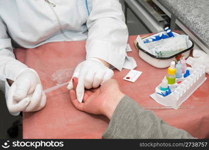 nurse collects blood specimen from a finger