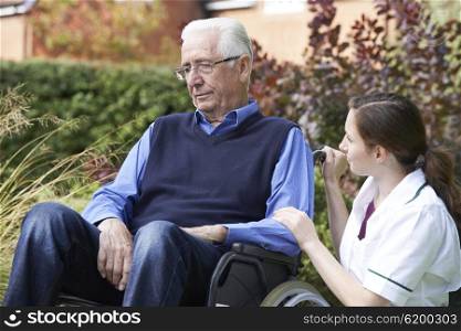 Nurse Comforting Senior Man In Wheelchair