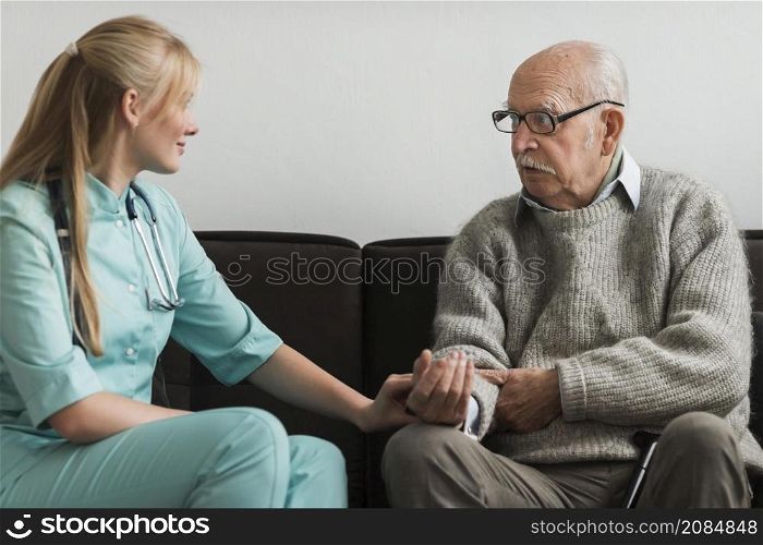 nurse consoling old man nursing home