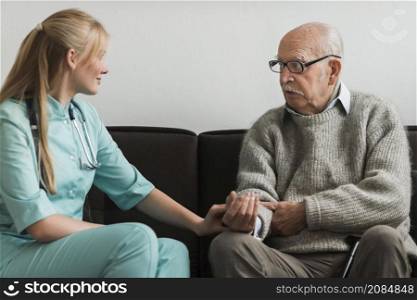 nurse consoling old man nursing home