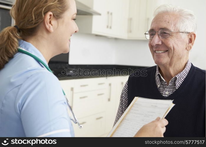 Nurse Discussing Medical Record With Senior Male Patient