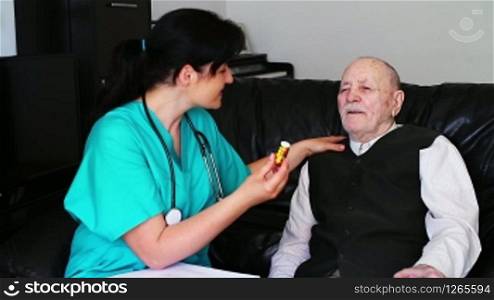 Nurse explaining how to take pills to a senior man