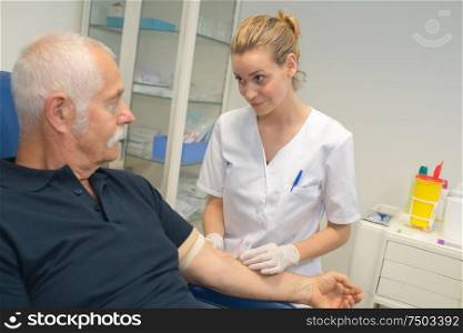 nurse finding patients vein for blood test