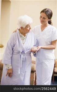 Nurse Helping Senior Woman To Walk
