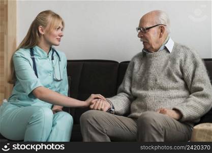 nurse holding old man s hand nursing home