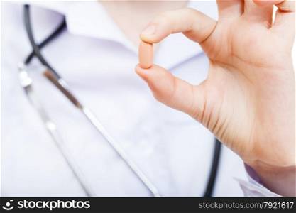 nurse holds drug in fingers close up