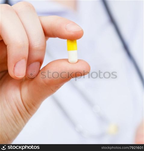 nurse holds pill in fingers close up