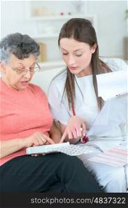 nurse in home visit helping old woman following treatment