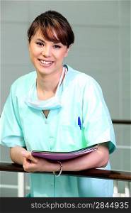 Nurse in scrubs holding files