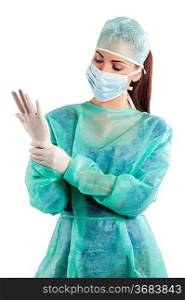 nurse in surgery dress with cap and mask in act to dress gloves