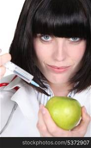 Nurse injecting drug in apple