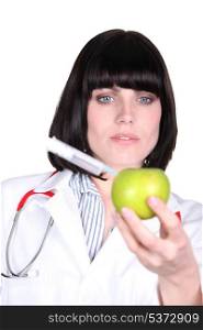 Nurse injecting syringe in apple