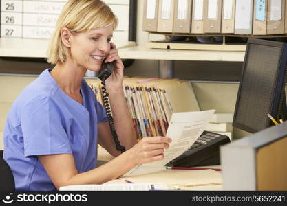 Nurse Making Phone Call At Nurses Station