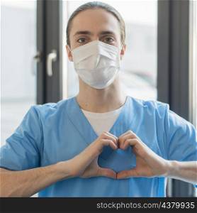 nurse male with medical mask showing heart shape