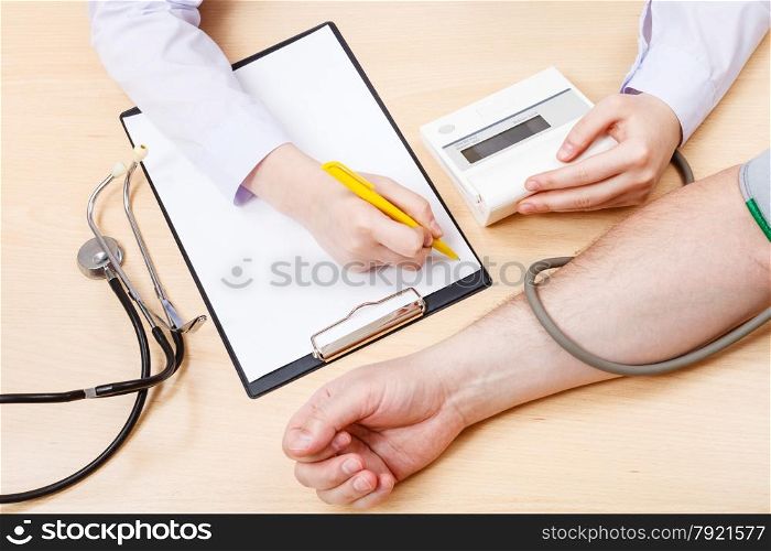 nurse measures blood pressure of patient during appointment
