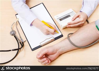 nurse measures blood pressure of patient during appointment