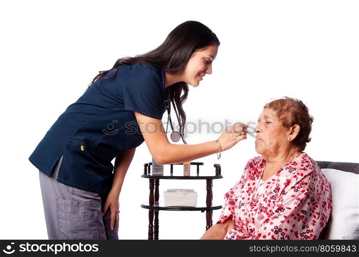 Nurse measuring temperature of senior woman, healthcare home health concept.