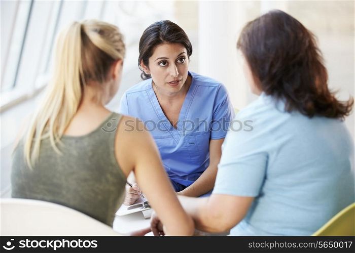 Nurse Meeting With Teenage Girl And Mother In Hospital