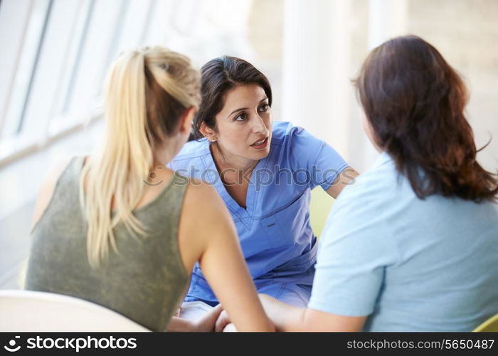 Nurse Meeting With Teenage Girl And Mother In Hospital