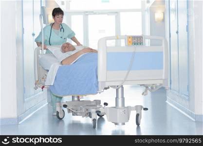 nurse pushing patient bed corridor