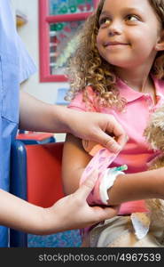 Nurse putting bandage on girl