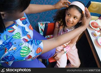 Nurse putting headband on girl