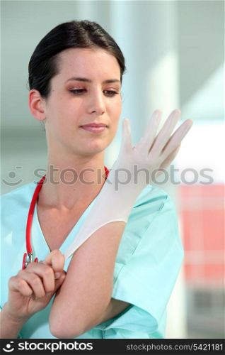 Nurse putting on gloves