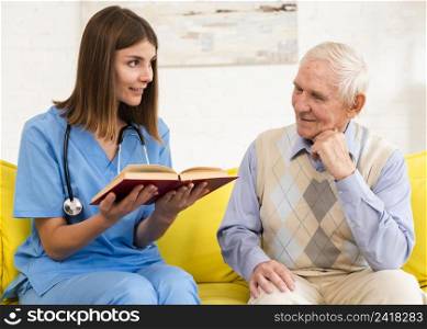 nurse reading book old man
