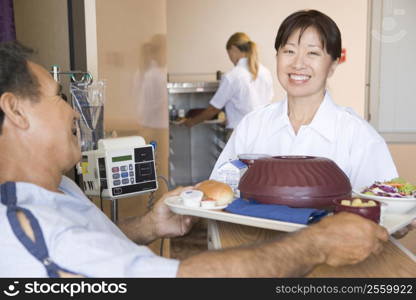 Nurse Serving A Patient A Meal In His Bed