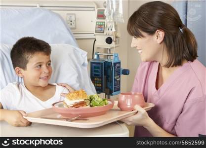 Nurse Serving Child Patient Meal In Hospital Bed