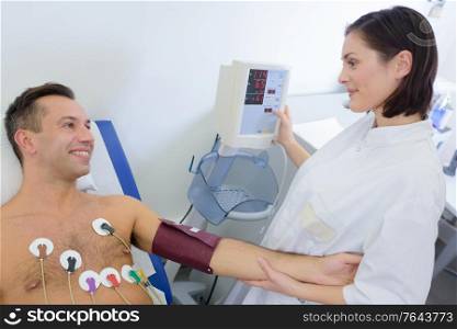 Nurse taking blood pressure of cardiac patient